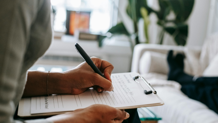 Therapist writing notes in notebook.